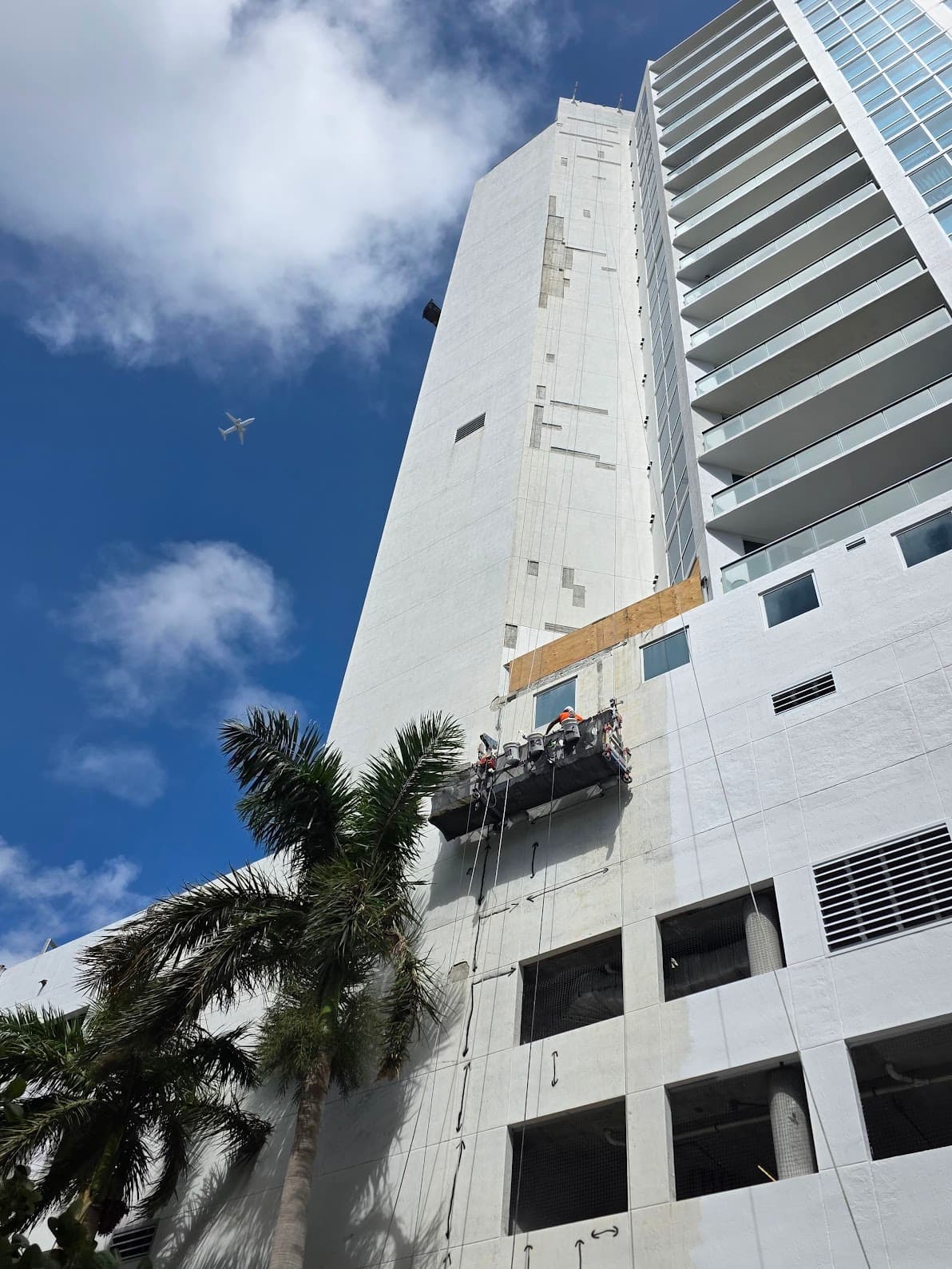 United Restoration crew repairing a high-rise facade from a swing stage